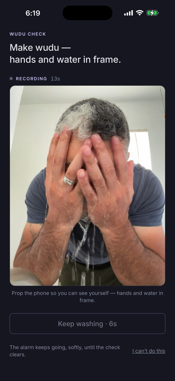 Mashhud's Wudu check, recording: under the heading “Make wudu — hands and water in frame,” the live camera shows a man washing his face with both hands, water running down his forearms. Below the camera: a “Keep washing · 6s” button and the line “The alarm keeps going, softly, until the check clears.”